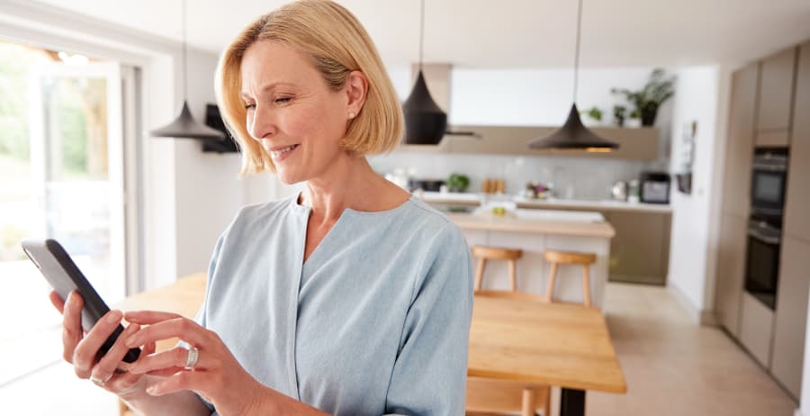 Resident with mobile device in a room filled with sunlight